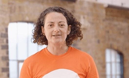 A female exercise instructor with an orange t shirt
