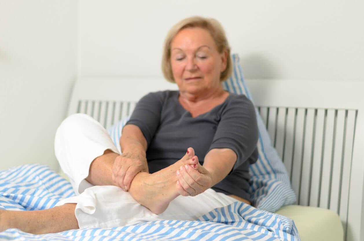 Woman looking at her feet sat on a bed