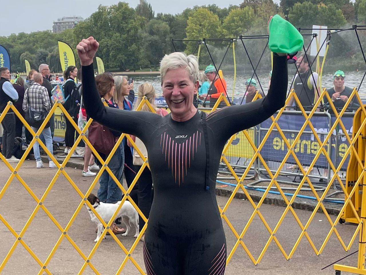 A woman swimmer standing by the Serpentine lake in London