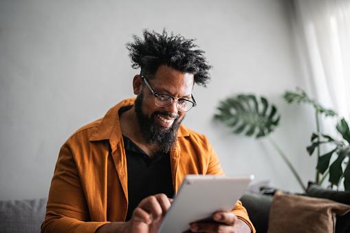 younger man smiling using tablet device