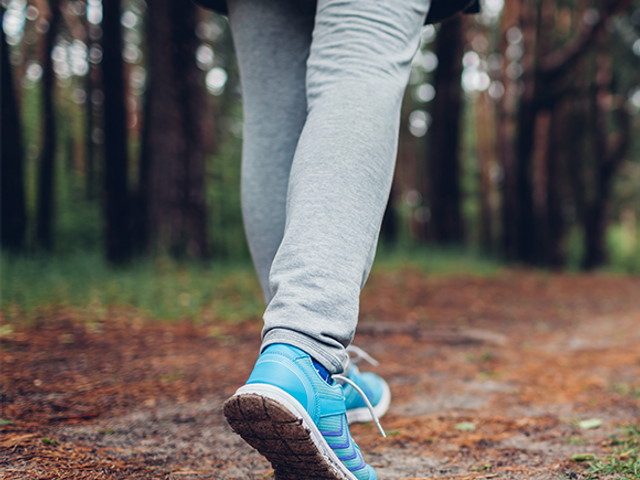 A close up of someone's feet walking in a forest