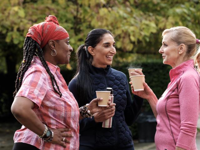 Women chatting outside with coffee